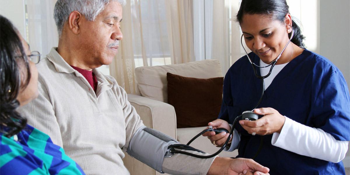 Health professional taking a senior's blood pressure.